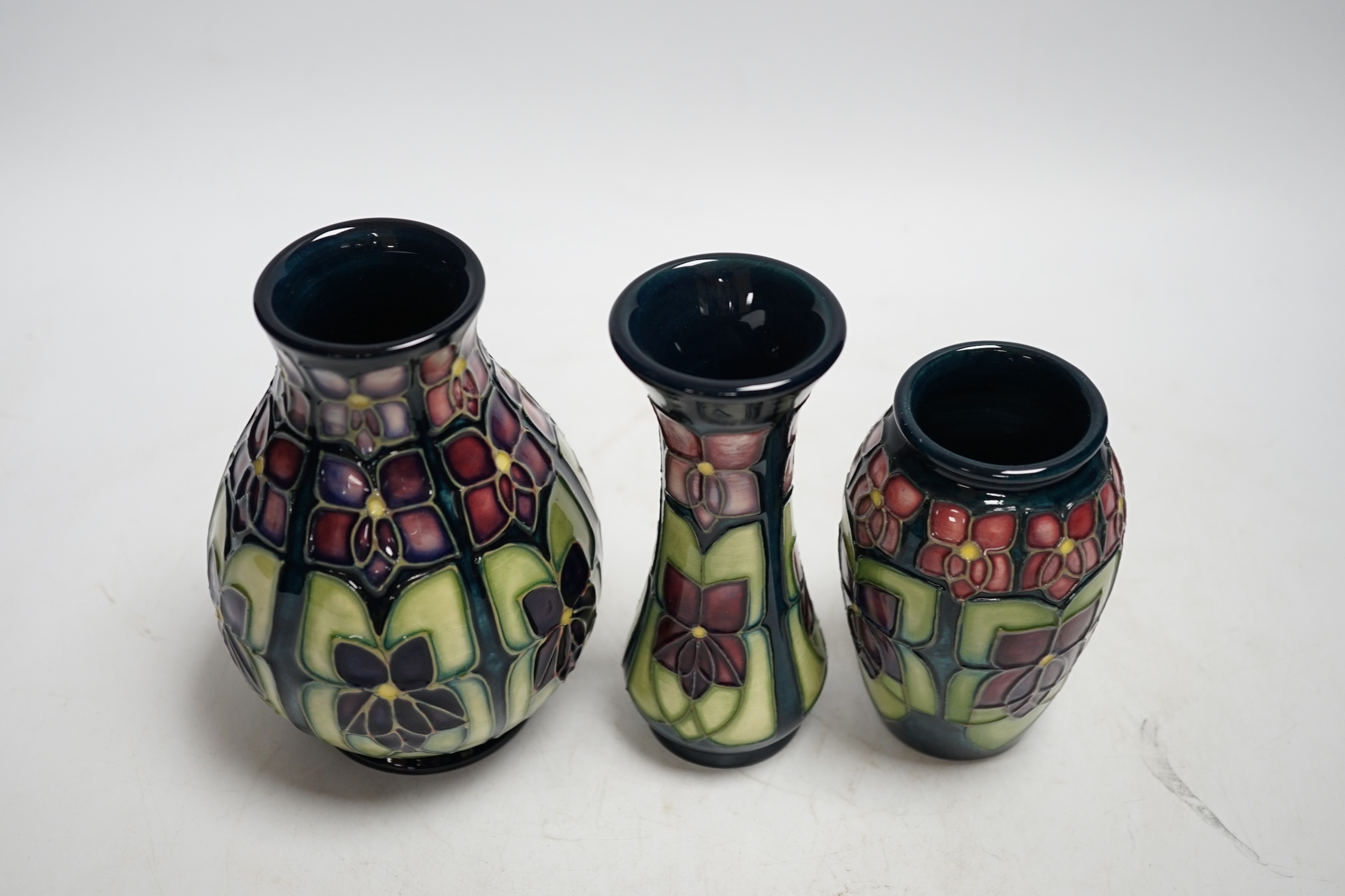 Three Moorcroft violet pattern vases, tallest 13.5cm